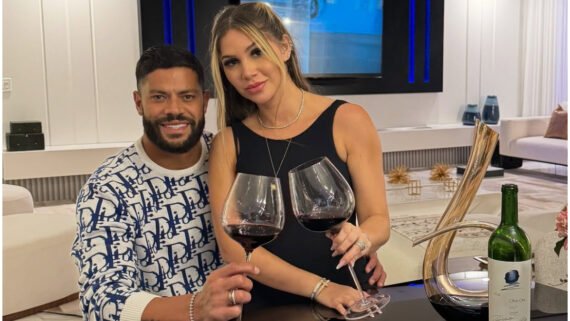 Hulk com a esposa no colo. Ambos com uma taça de vinho posando para foto. (foto: Arquivo pessoal)