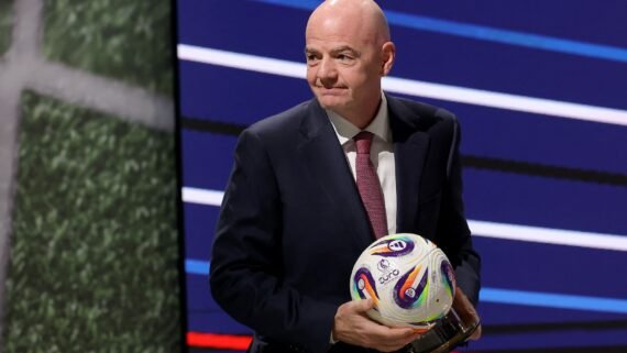 Gianni Infantino segurando uma bola (foto: Predrag Milosavljevic / AFP)