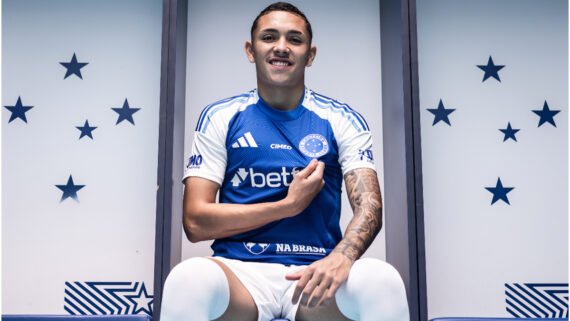 Kauã Moraes, atleta no Cruzeiro posando para foto com a mão no escudo do time na camisa. (foto: Gustavo Aleixo/Cruzeiro)