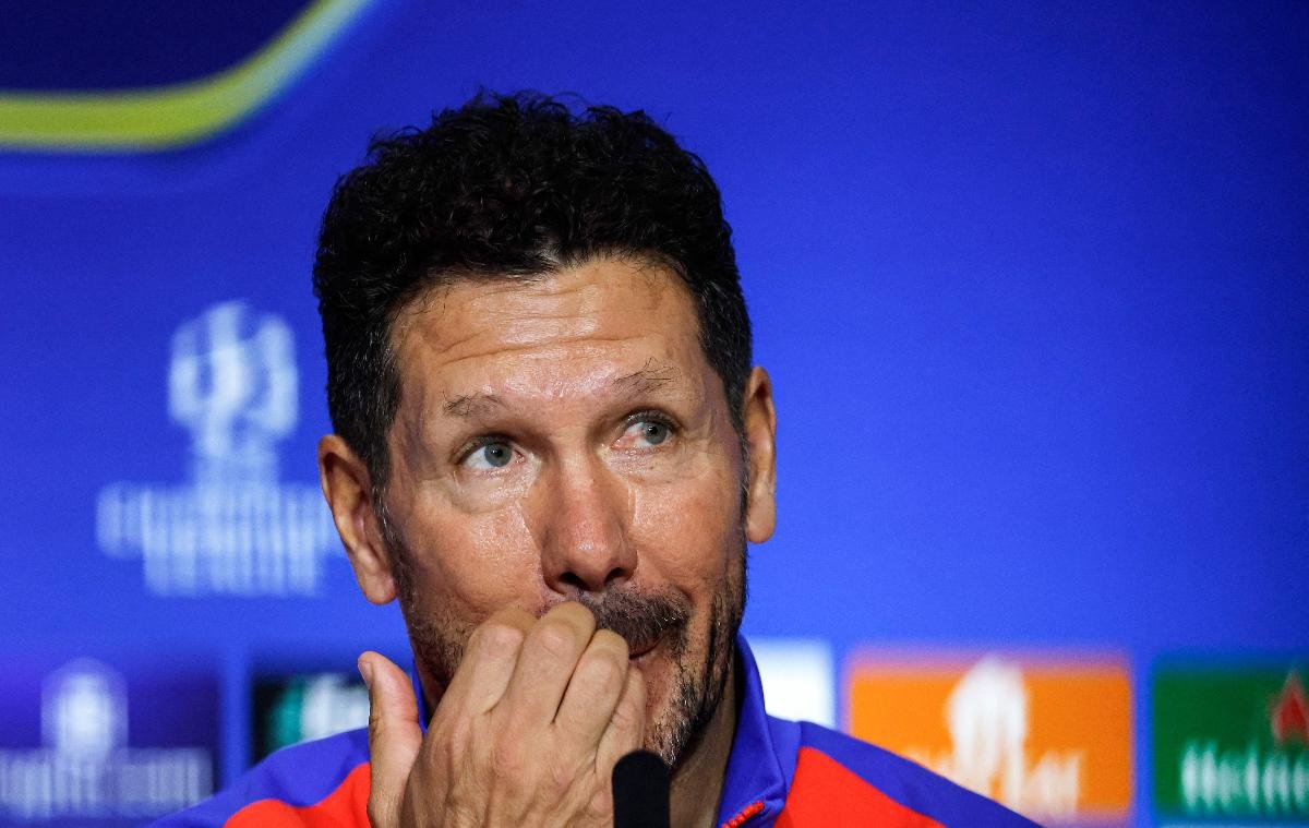 Simeone coça a boca durante coletivo à frente de fundo azul - (foto: Oscar del Pozo/AFP)
