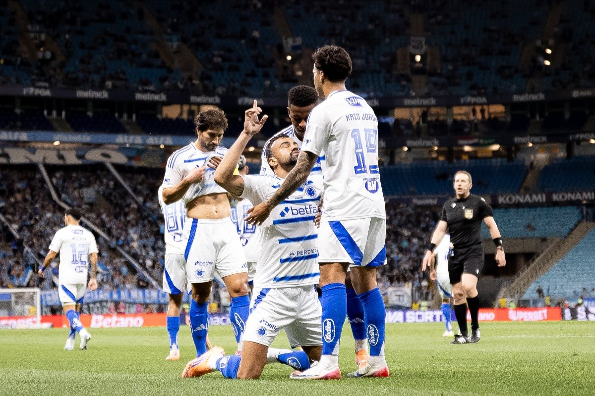 Jogadores do Cruzeiro comemorando gol; zagueiro Fabrício Bruno ajoelhado agradecendo a Deus (foto: Lucas Bubols/Cruzeiro)