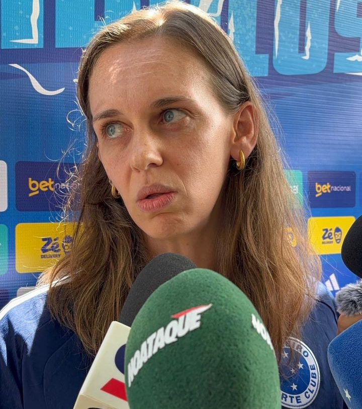 Luiza Parreiras de camisa azul do Cruzeiro e à frente o microfone verde com os escritos em branco No Ataque (foto: Sofia Cunha/No Ataque)