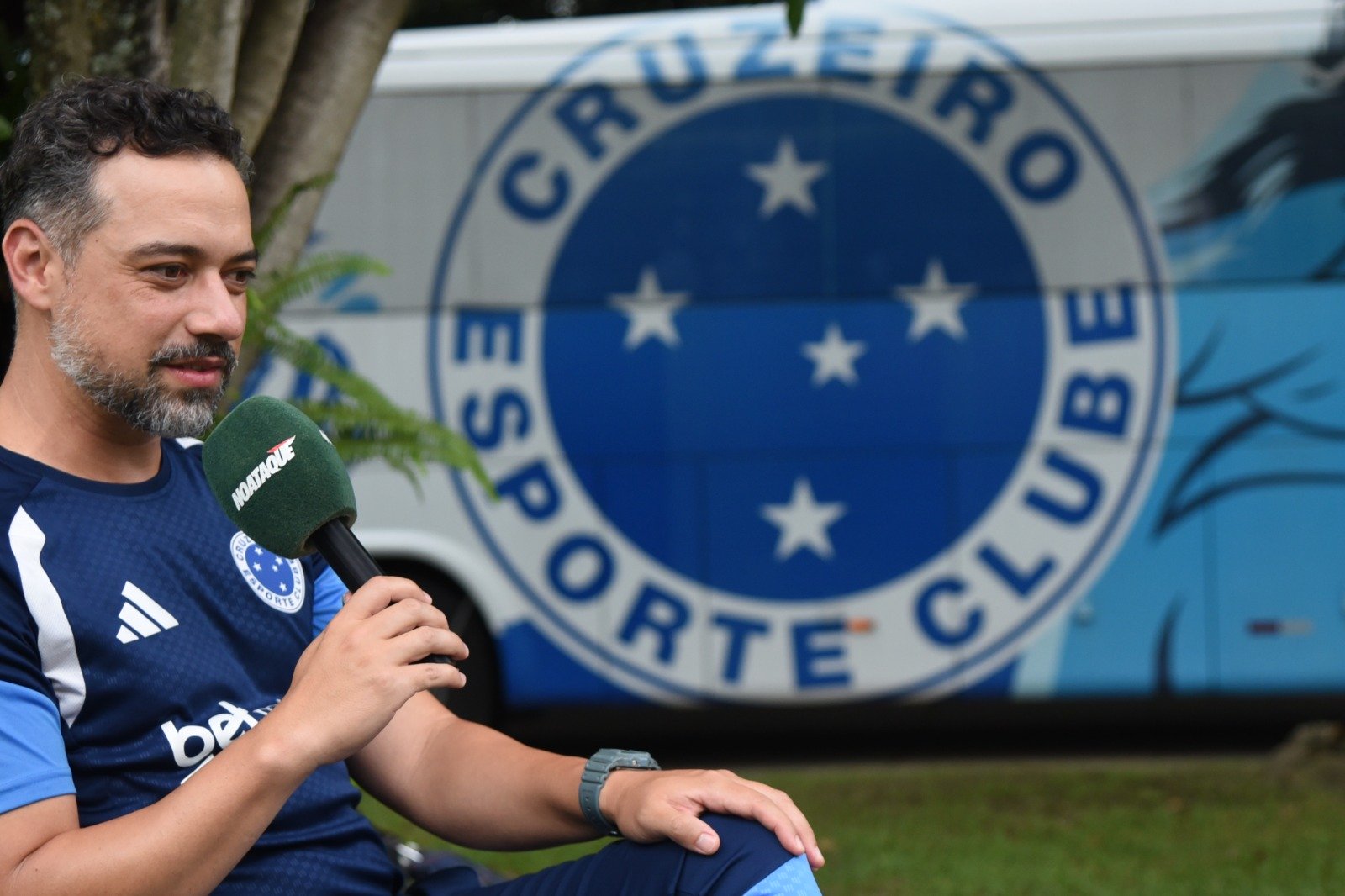 Jonas Urias posicionado de lado vestido com o uniforme do Cruzeiro, microfone do No Ataque na mão direita e ao fundo o escudo do Cruzeiro - (foto: Gladyston Rodrigues/EM/D.A Press)
