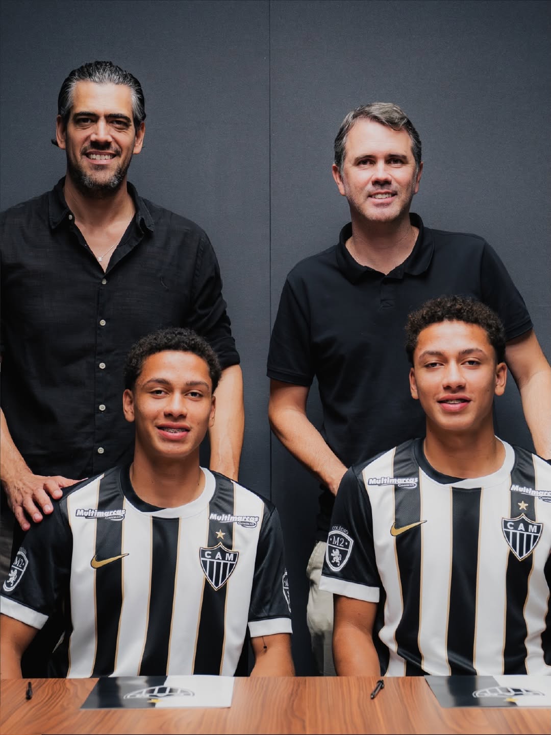 Samuel Rodrigues e Vinícius Rodrigues posam para foto na assinatura de contratos com Paulo Bracks (vice-presidente de futebol) e Luiz Carlos Azevedo (gerente das categorias de base) - (foto: Divulgação/Atlético)