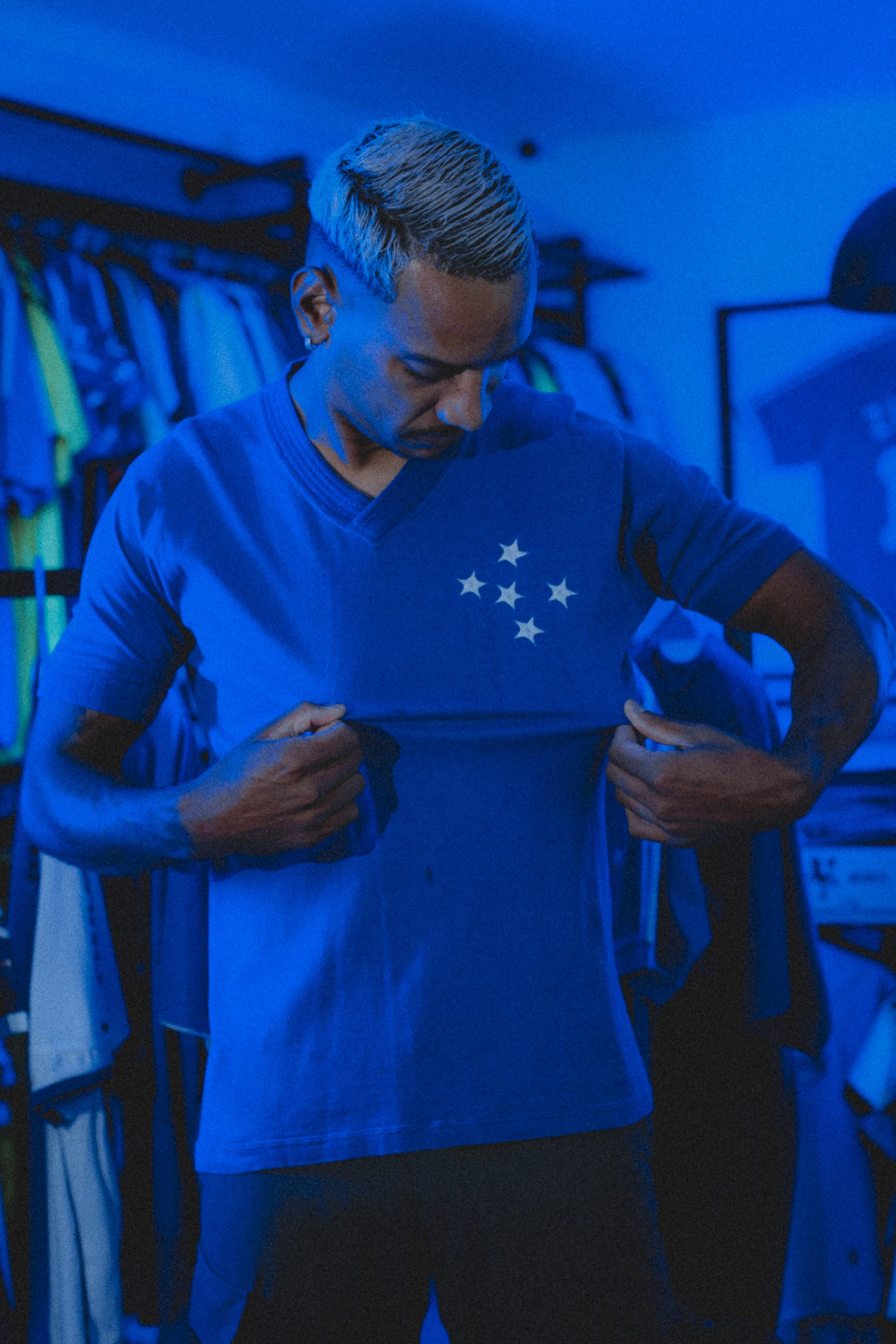 Matheus Pereira olhando para o escudo do Cruzeiro