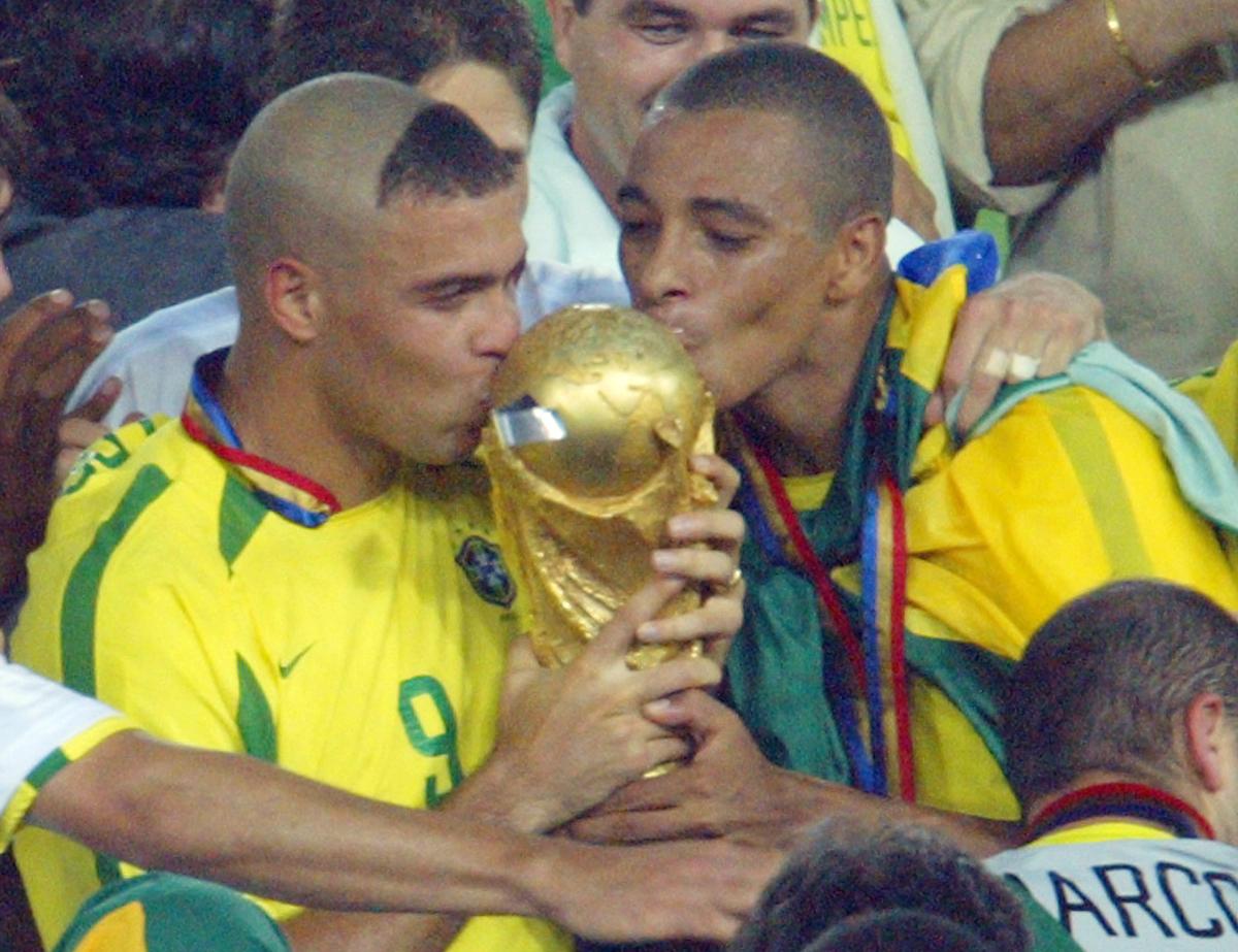 Gilberto Silva (direita) beija o troféu da Copa do Mundo junto com Ronaldo Fenômeno - (foto: ODD ANDERSEN/AFP)